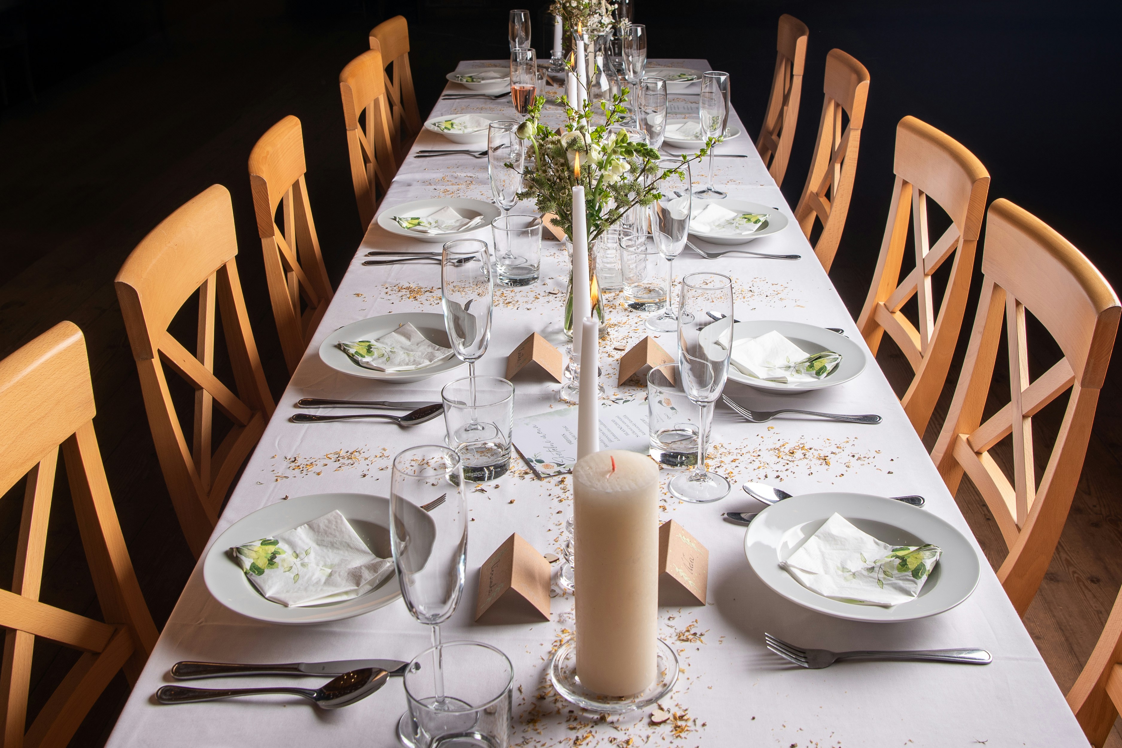 Beautifully positioned cross-back seating at an open-air harvest table setup