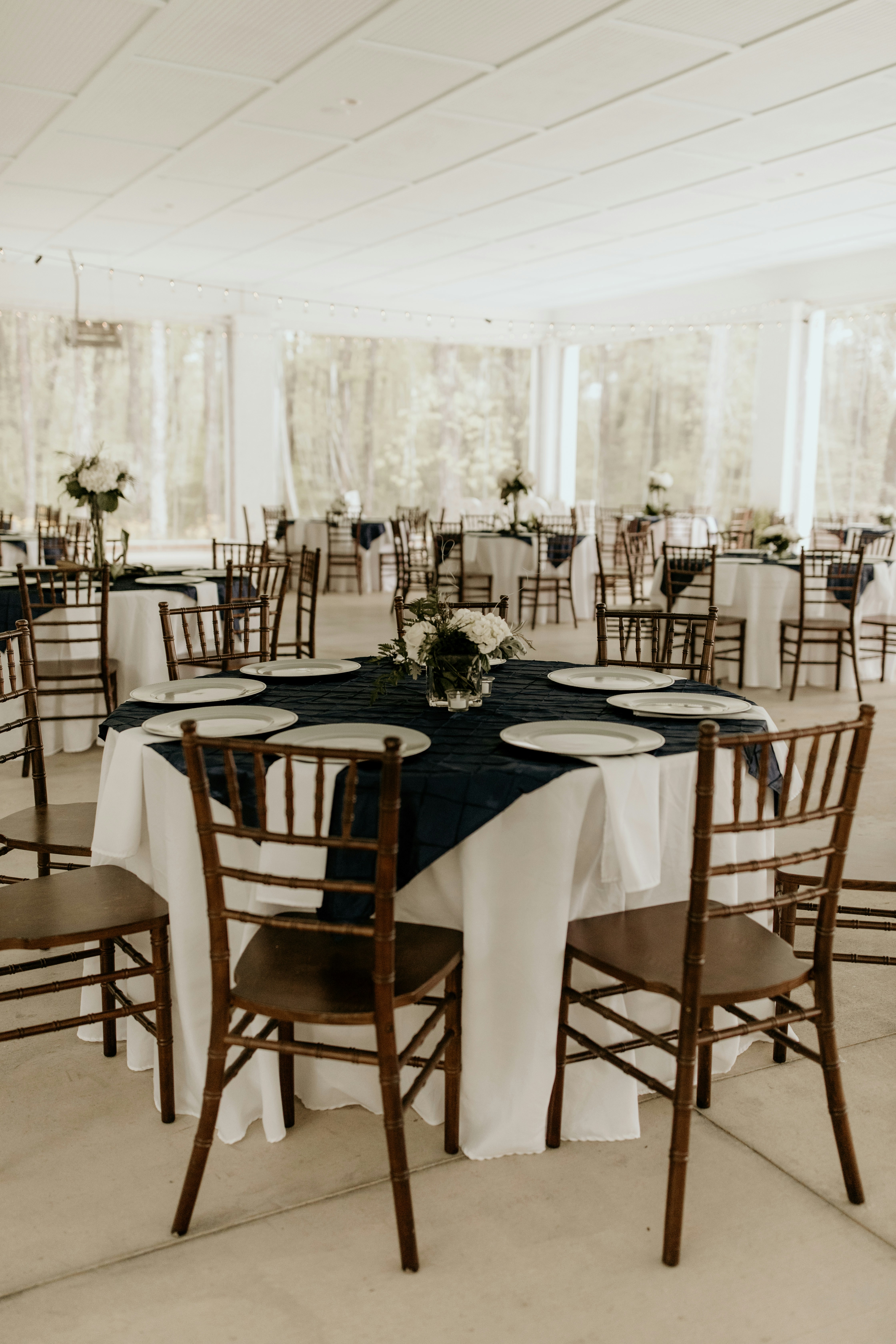Elegantly dressed table with Chiavari chairs, high-end lines, floral centerpieces and sophisticated dining arrangements